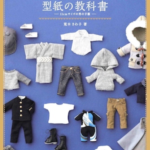 May include: A blue book cover with Japanese text and miniature doll clothes. The book title is "Obitsu 11 no Katagami no Kyokasho" and features various outfits, including a kimono, jeans, a hoodie, and a blazer. The clothes are designed for 11cm dolls.