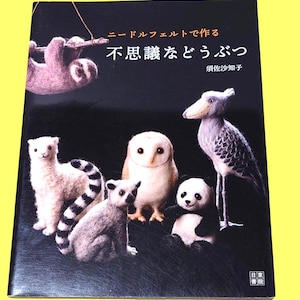 May include: A book cover featuring needle felted animal figures, including a sloth, owl, panda, and lemur, against a dark background. Japanese text is visible at the top and center of the cover.