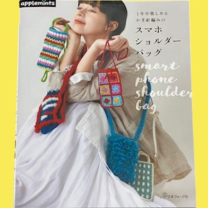 以下が含まれることがあります： 「smart phone shoulder bag」のテキストと日本語のテキストが書かれた本の表紙。画像には、青、赤、マルチカラーのパターンなど、さまざまな色とデザインの、かぎ針編みの電話バッグをいくつか持っている女性が写っています。