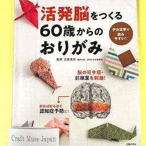 May include: A book cover with a colorful origami crane and the text "活発脳をつくる 60歳からの おりがみ" which translates to "Create an active brain: Origami for those over 60". The book cover also features a brain with a red and orange section highlighted, and the text "脳の司令塔・前頭葉を刺激!" which translates to "Stimulate the prefrontal cortex, the command center of the brain!"