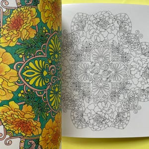 May include: A coloring book with two pages visible. The left page features a floral mandala design colored in vibrant yellow, orange, and green. The right page displays the same intricate floral mandala pattern in black and white line art.