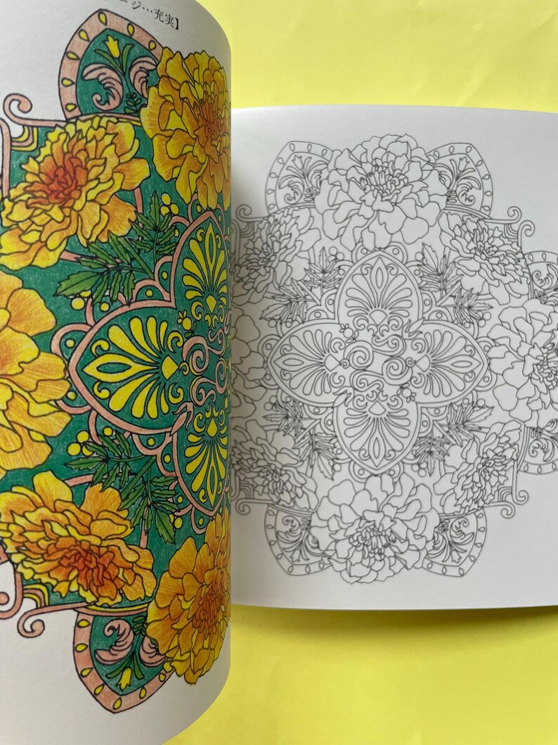 May include: A coloring book with two pages visible. The left page features a floral mandala design colored in vibrant yellow, orange, and green. The right page displays the same intricate floral mandala pattern in black and white line art.