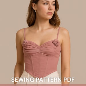 Peut inclure: Bustier rose poudré avec un design drapé et baleines. Le haut présente des accents de roses sur les bretelles et est un patron de couture PDF. Le texte de l'image indique "ROSE BUSTIER", "SEWING PATTERN PDF", "ROMANTIC CORSET TOP WITH DRAPED DESIGN AND BONING", et "S-2XL".