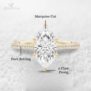 May include: A gold engagement ring with a marquise-cut diamond. The ring features a pave setting on the band and a six-claw prong setting. The ring is set against a white background. The brand name "ZELIFIYA" is in the top left corner.