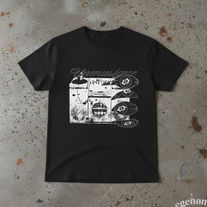 May include: A black short-sleeved t-shirt featuring a white graphic print of a vintage DJ turntable and mixer setup. The text "Unmusique" is printed above the equipment, and four stylised eye icons are arranged vertically on the right side.
