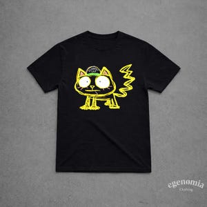 Puede incluir: Camiseta negra con un diseño de gato amarillo de dibujos animados. El gato tiene ojos grandes y una expresión preocupada, y lleva un sombrero verde con la inscripción "Scared Cat". El diseño tiene un estilo dibujado a mano, con una cola en zigzag. La camiseta es de la marca "egenomia clothing".