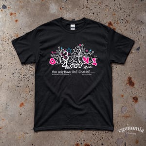 Op de afbeelding: Een zwart t-shirt met korte mouwen en een grafisch ontwerp met de tekst "ONE CHANCE" in roze, "3" in wit en "4th on tour" in wit. Aanvullende tekst luidt "You only Have OnE ChaNcE.....", "RIVERSIDE TOUR OFFICIAL 1C" en "EU EXCLUSIVE".