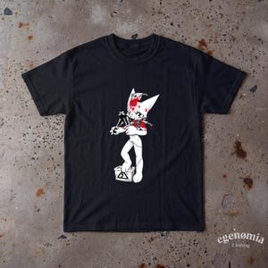 May include: A black short-sleeved t-shirt featuring a graphic of a white cartoon creature with red blood splatters, holding a black object, and standing on a grey battery with a lightning bolt symbol. The text "egenomia Clothing" is printed in white.