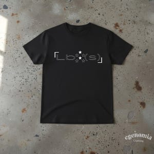 Op de afbeelding: Een zwart t-shirt met korte mouwen en een witte grafische print op de borst. Het ontwerp bestaat uit de tekst Lb(s) tussen haakjes, met drie gestapelde witte sterren tussen de letters b en s in het midden.