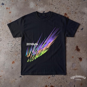 Op de afbeelding: Een zwart T-shirt met korte mouwen en een afbeelding van diagonale, veelkleurige strepen in tinten paars, oranje, geel en groen. De tekst 2016lyfe is in het wit gedrukt aan de linkerkant van de afbeelding die over de borst uitloopt.
