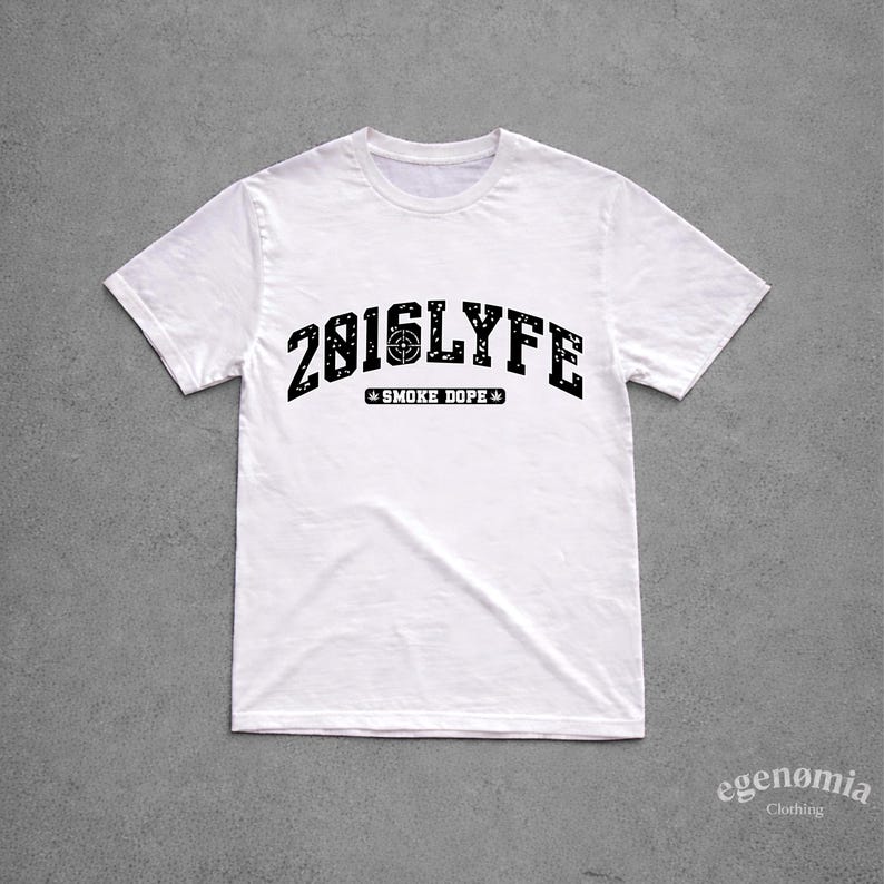 K&ouml;nnte beinhalten: Ein wei&szlig;es Kurzarm-T-Shirt mit einer schwarzen, abgenutzten Grafik auf der Brust. Der Text lautet 2816LYFE mit einem Zielsymbol in der Mitte, gefolgt von dem Text SMOKE DOPE, der von zwei kleinen Blattsymbolen flankiert wird.