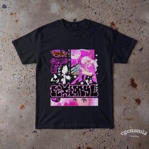 Könnte beinhalten: Ein schwarzes Kurzarm-T-Shirt mit einem Grafikdruck, der eine rosa-weiße Anime-Figur mit einer Sense, eine Pistolenillustration, japanischen Text sowie stilisierte Blasenbuchstaben und eine Nahaufnahme von Augen zeigt.