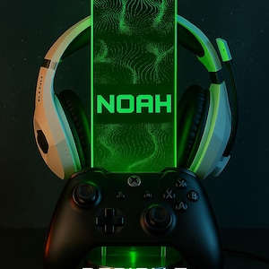 May include: A black Xbox controller sits on a stand, with a green-lit panel behind it displaying the name "NOAH". White and black gaming headphones frame the panel. The text "DESIGN 7" is below the controller.