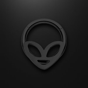 May include: A black, circular piece of jewelry with an alien face design. The alien face has large, oval eyes and a small, curved mouth. The jewelry is set against a black background.