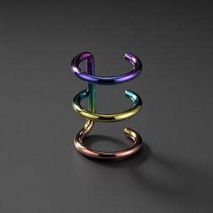 Pode incluir: Um ear cuff de várias camadas com um acabamento liso e polido e um gradiente de cores vibrante. A banda metálica muda de tom, passando do roxo escuro no topo, pelo azul e verde no meio, até um tom de cobre quente na base.