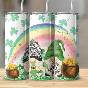 May include: Three stainless steel tumblers with a St. Patrick's Day theme. Each tumbler features a design of a rainbow, shamrocks, and gnomes. One gnome wears a leopard print hat. Each tumbler has a white straw.