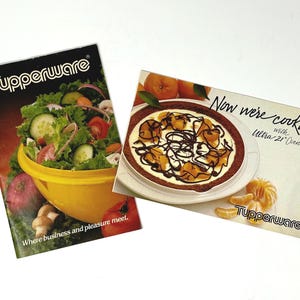 Puede incluir: Dos folletos vintage de Tupperware. Uno presenta una ensalada en un cuenco amarillo, el otro un postre. El texto del primer folleto dice: "Where business and pleasure meet". El segundo dice: "Now we're cooking with Ultra 21 Ovenware".