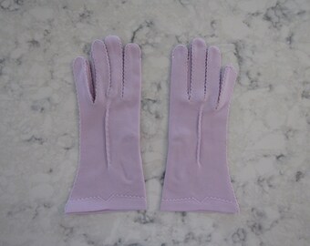 Könnte beinhalten: Ein Paar lavendelfarbene Handschuhe mit einem gewellten Rand.