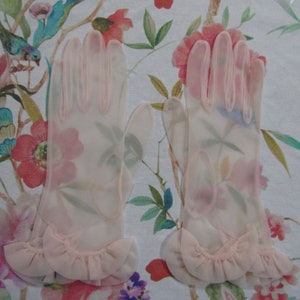May include: A pair of delicate, sheer pink gloves with ruffled edges. The gloves are made of a lightweight, translucent fabric and have a classic, elegant design.