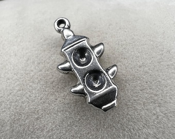 May include: A small, silver-colored charm in the shape of a stylized speaker. The charm has two circular speaker details and four pointed protrusions. It has a small loop at the top for attaching to a chain or bracelet.