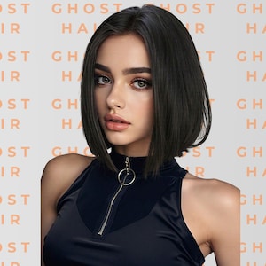 May include: A woman with dark hair styled in a blunt bob, wearing a black top with a zipper and a ring detail. The background features the repeated text "GHOST HAIR" in a peach color.