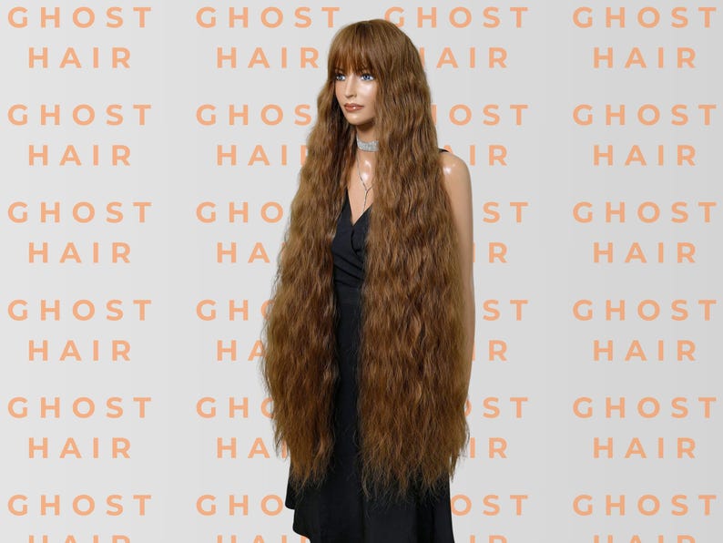 May include: A long, wavy auburn wig with a fringe is displayed on a mannequin. The wig is styled with voluminous, crimped waves. The background features the words "GHOST HAIR" in a repeating pattern.