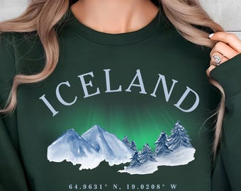 Puede incluir: Sudadera verde bosque con la palabra "ICELAND" en blanco. Debajo, un gráfico de montañas y árboles, con el texto "The Land of Fire and Ice".