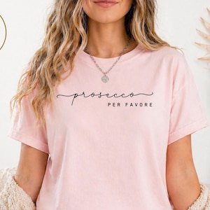 Celebrate your love for bubbly with our “prosecco please” minimalist tee – designed for the wine lover with a taste for elegance, sass, and simplicity. This clean, modern design features soft handwritten script paired with bold caps, making it perfect for brunches, wine tastings, vacations, or casual nights out with the girls.