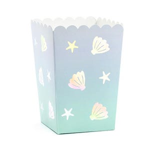 May include: A mermaid-themed popcorn box with a scalloped edge. The box features a blue and green gradient, adorned with seashell and starfish motifs. The seashells have an iridescent finish.