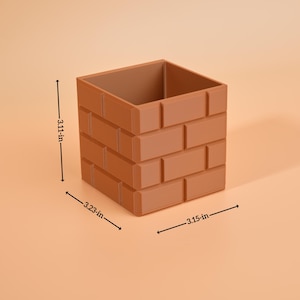 May include: A brown, brick-effect container, measuring 7.9 cm high, 8.2 cm wide, and 8 cm deep. The square-shaped container has a hollow interior and is designed to resemble a brick wall. The product is suitable for home decor.