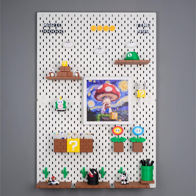 Puede incluir: Un tablero perforado blanco con varios accesorios tem&aacute;ticos de Super Mario. Incluye una impresi&oacute;n enmarcada de un hongo al estilo de La noche estrellada de Van Gogh, junto con estantes, figuras y el texto "MARIO" y "TIME 999".