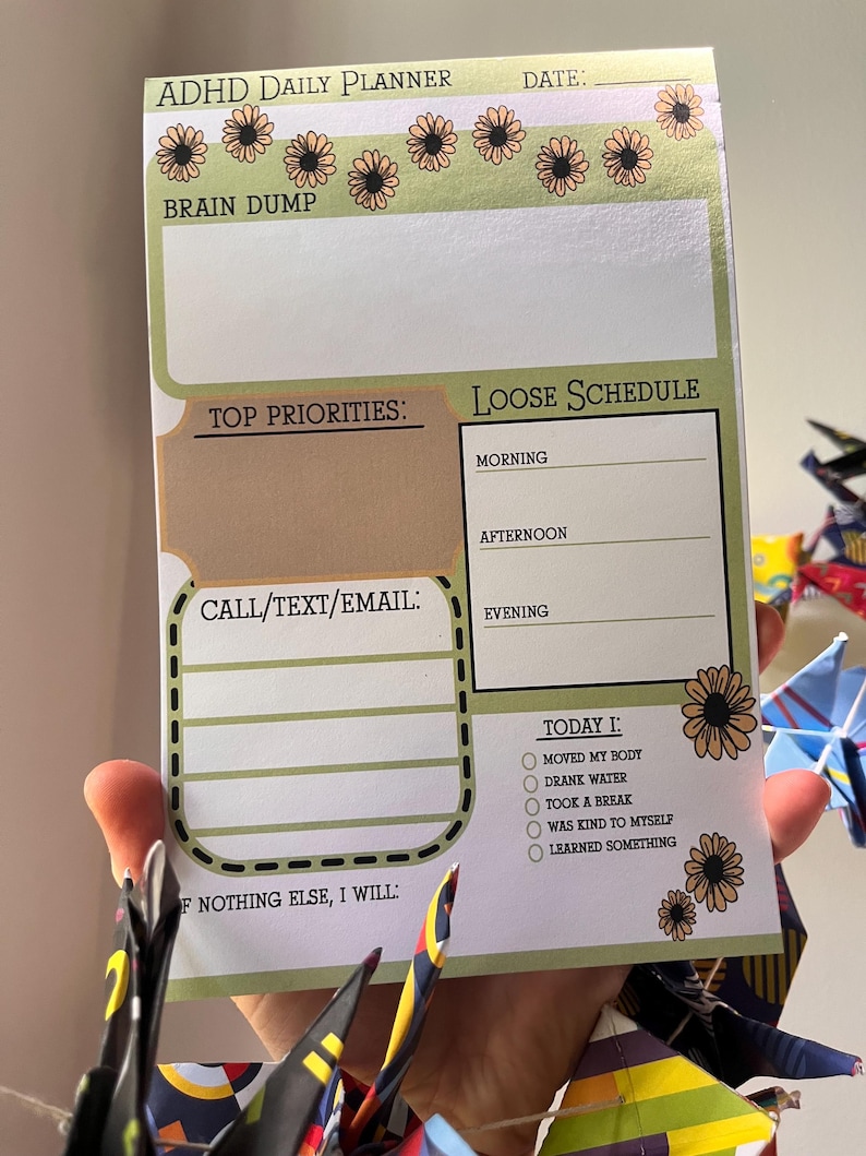 May include: ADHD daily planner with a green and tan floral design. The planner includes sections for a brain dump, top priorities, a loose schedule, and a checklist for daily tasks. The text "ADHD Daily Planner" is at the top.
