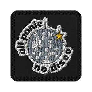 May include: Embroidered patch featuring a disco ball design. The disco ball is grey and white, with a yellow star. The text "all panic no disco" is embroidered around the disco ball on a black square.