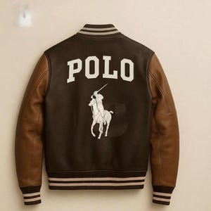 May include: A brown and black varsity jacket with the word "POLO" in white block letters on the back. The jacket features brown leather sleeves and a white polo player logo. The cuffs and collar have striped detailing.
