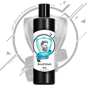 Könnte beinhalten: Eine schwarze Flasche mit Bartwaschmittel mit einem weißen Etikett. Das Etikett zeigt einen Cartoon-Mann mit Bart, den Text "Alpine Mist", "Fresh Mountain Air", "Beard Wash" und "4oz".