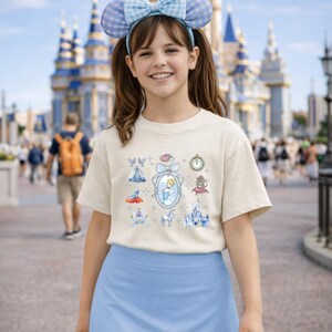 May include: A white ceramic mug with a black handle and the text "But First, Coffee" in a bold, black font. The mug is set against a blurred background, suggesting a cozy setting.