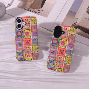 Puede incluir: Dos fundas para smartphone con un diseño de patchwork multicolor y vibrante. Cada funda muestra una cuadrícula de pequeños cuadrados distintos rellenos con varios patrones florales y geométricos en tonos brillantes de rosa, amarillo, verde y azul.