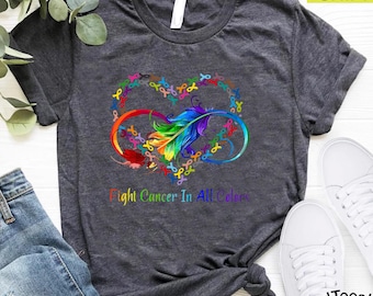 May include: A dark grey t-shirt with a rainbow infinity symbol and a feather in the center. The infinity symbol is made up of awareness ribbons. The text "Fight Cancer In All Colors" is printed below the symbol.