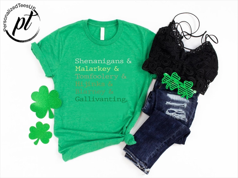 May include: A green t-shirt with the words "Shenanigans & Malarkey & Tomfoolery & Hijinks & Blarney & Gallivanting" printed on it. The image also includes a black lace top, blue jeans, and green shamrock-shaped sunglasses and decorations.
