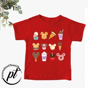 May include: Red short-sleeved t-shirt with a Mickey Mouse design featuring various Disney food items, including ice cream, pizza, cupcakes, and donuts.