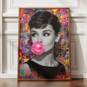 May include: A framed black and white portrait of a woman blowing a bubblegum bubble. The background is a colorful abstract painting with splashes of pink, yellow, blue, and green. The woman is wearing a black dress.