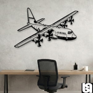 Może przedstawiać: Czarna metalowa dekoracja ścienna w kształcie wojskowego samolotu transportowego C-130 Hercules. Projekt zawiera cztery śmigła, konfigurację górnopłata oraz napis U.S. AIR FORCE wyraźnie nadrukowany na boku kadłuba samolotu.