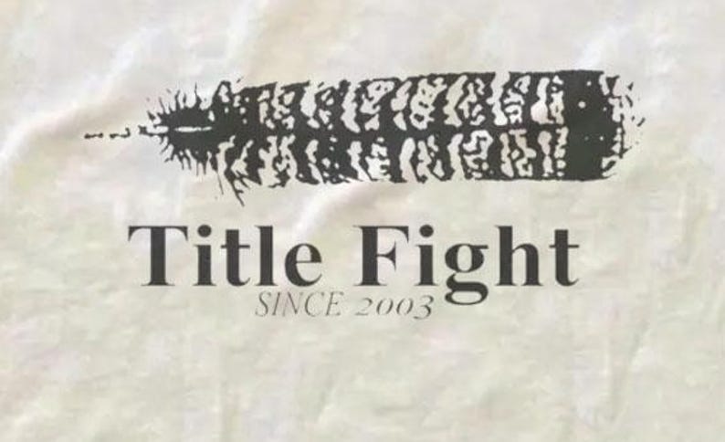 May include: A white background with a black feather design and the words "Title Fight" and "Since 2003" in a serif font. The feather is stylized and textured.