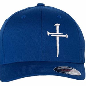 May include: A blue baseball cap with a white embroidered cross design. The cap has a curved brim and a Flexfit tag. The cap is made of a durable fabric and has a structured fit.