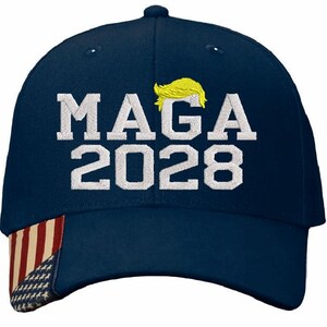 May include: A navy blue baseball cap with a white American flag on the side. The front of the cap has white embroidery that says "MAGA 2028" with a yellow silhouette of a hairstyle above the text.