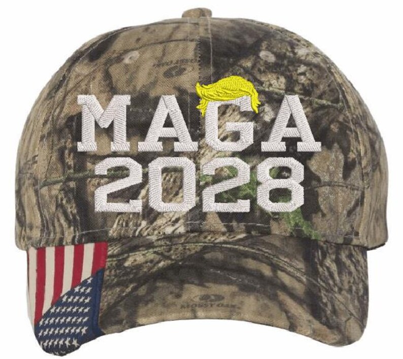 May include: A camouflage baseball cap with a white embroidered American flag on the side. The front of the cap has white embroidered text that says "MAGA 2028" and a yellow embroidered silhouette of a person's hair.