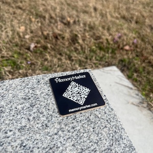 May include: A black square sticker with a QR code and the text "MemoryMarker" and "memorymarker.com".