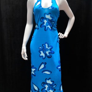 May include: A blue halter dress with a white floral pattern. The dress is sleeveless and has a fitted bodice. The skirt is midi-length and flows loosely.