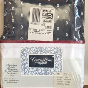 May include: A packaged set of Coming Home with Lands' End pillowcases. The top portion of the package features a navy blue fabric with white oval patterns. The bottom portion is white with a red border. The package includes two percale pillowcases.