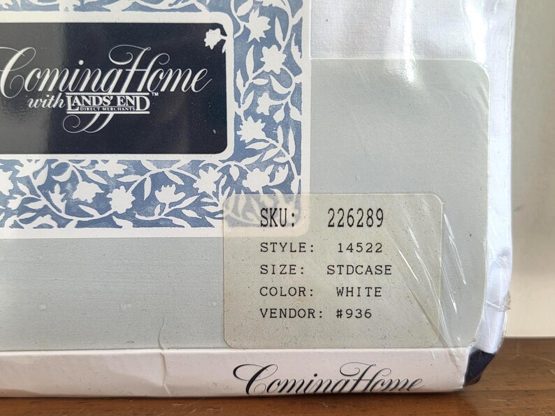 May include: A packaged white pillowcase from Coming Home with Lands' End. The packaging features a blue and white floral design and the brand name. A sticker displays the SKU, style, size, color, and vendor information.